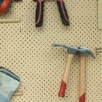 black and silver claw hammer beside red and black hand tool